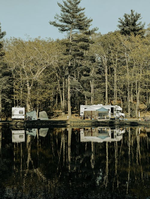 Camper at a campground in the summertime with lots of trees. 